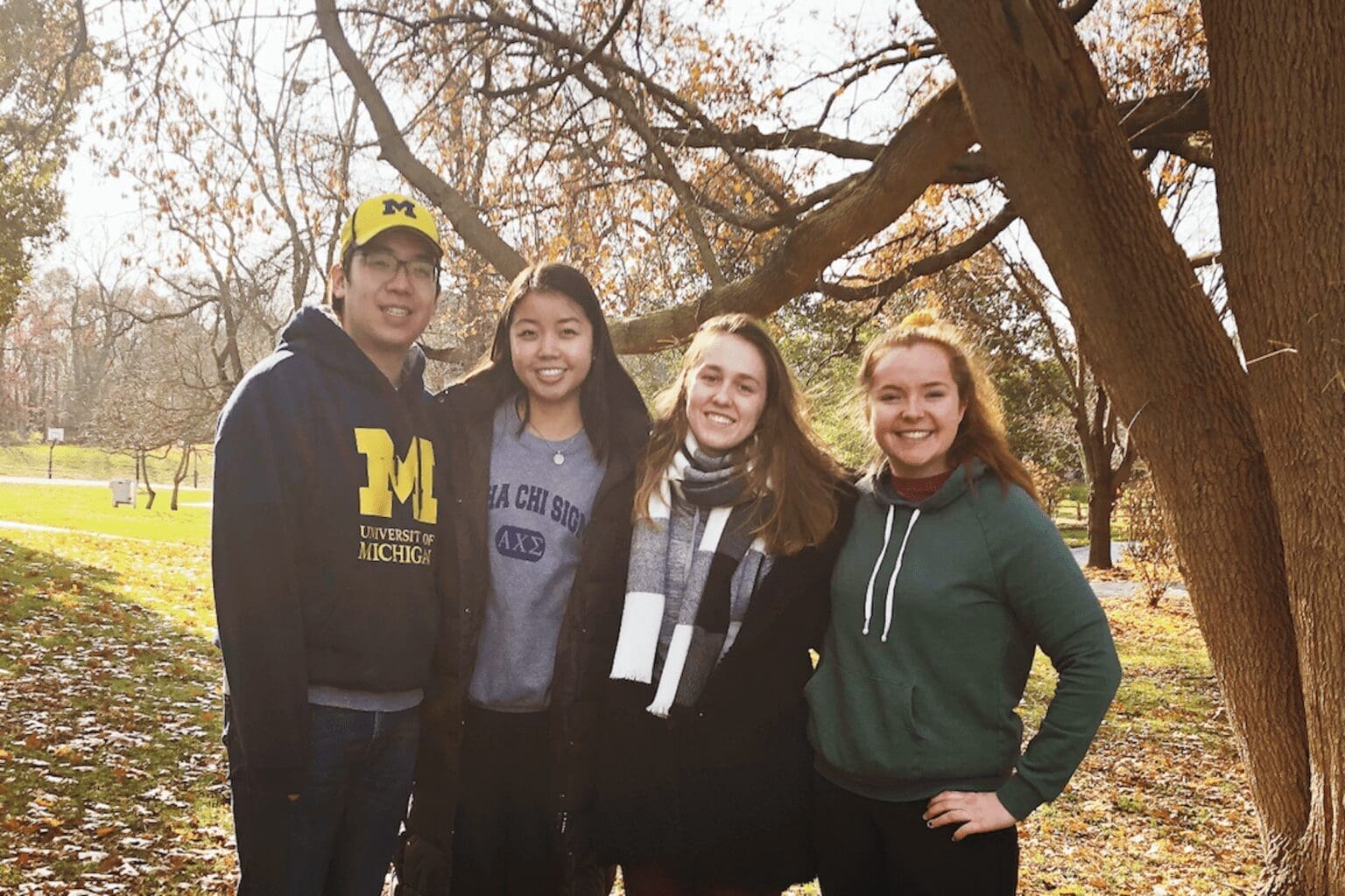 Four students smiling together outdoors in fall foliage at the Barger Leadership Mindful Leader Retreat.